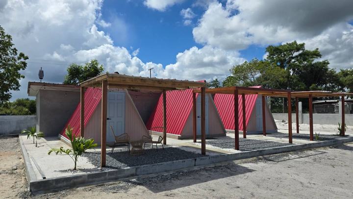Red-roofed A-frame cabins under timber pergolas