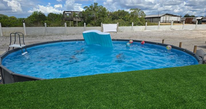 Guests swimming in the pool beside the turf